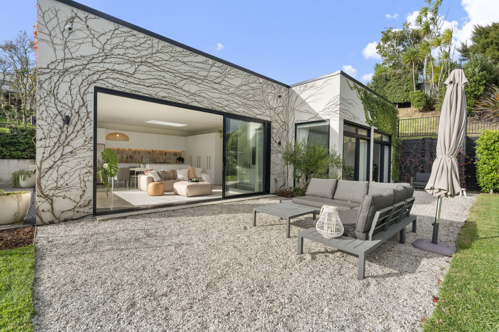 Modern Auckland home with manicured gravel courtyard, trimmed climbers and tidy frontage ready for open homes